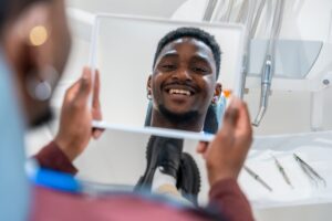 Happy,Patient,Looking,At,His,Whiter,Teeth,In,The,Mirror Happy,Patient,Looking,At,His,Whiter,Teeth,In,The,Mirror